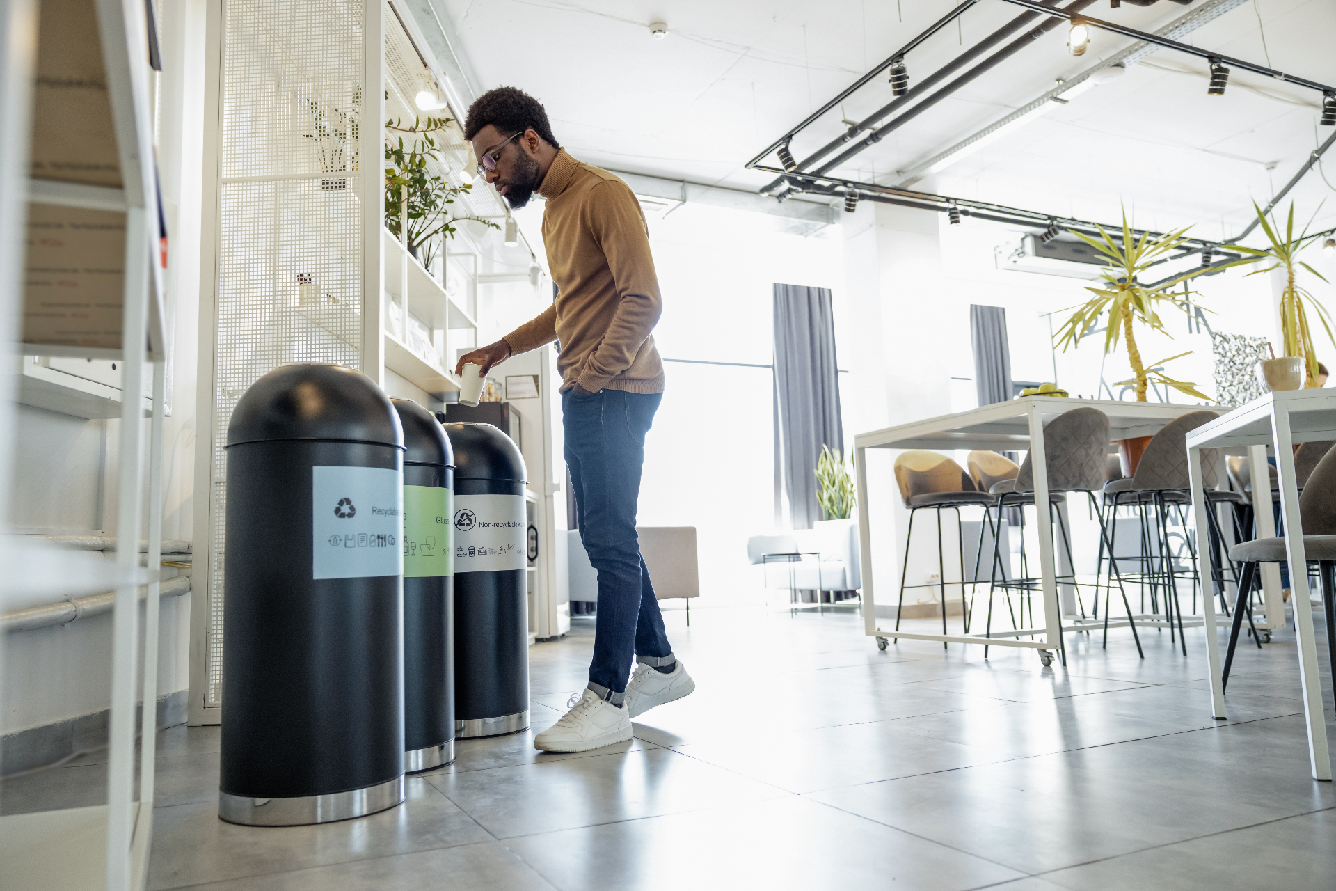 Collaborateur triant ses déchets dans des bacs de recyclage en entreprise